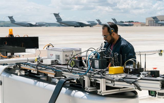 Ground Test Vehicle close-up with engineer at Travis AFB.