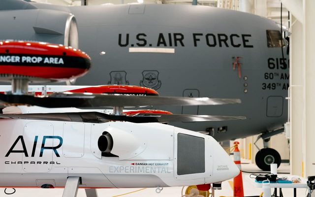 Side view of Chaparral in front of an Air Force jet in a hangar.