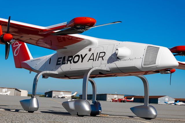 A close-up photo of the Chaparral ground test vehicle aircraft parked outside its hangar at Byron Airport, set against a blue sky.