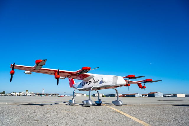 The Chaparral ground test vehicle aircraft parked outside its hangar at Byron Airport, set against a blue sky.